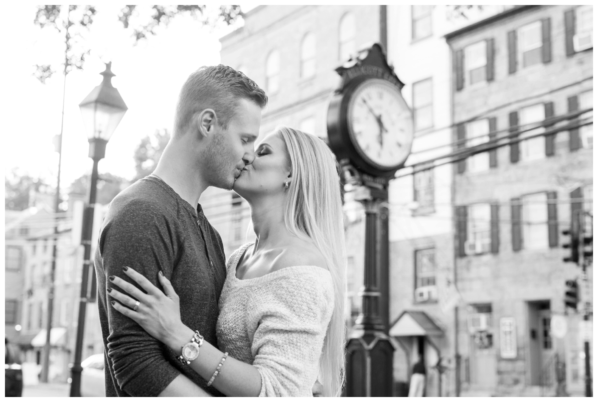 Ellicott City Engagement Photo by train bridge. Old Ellicott City. Kissing by the clock