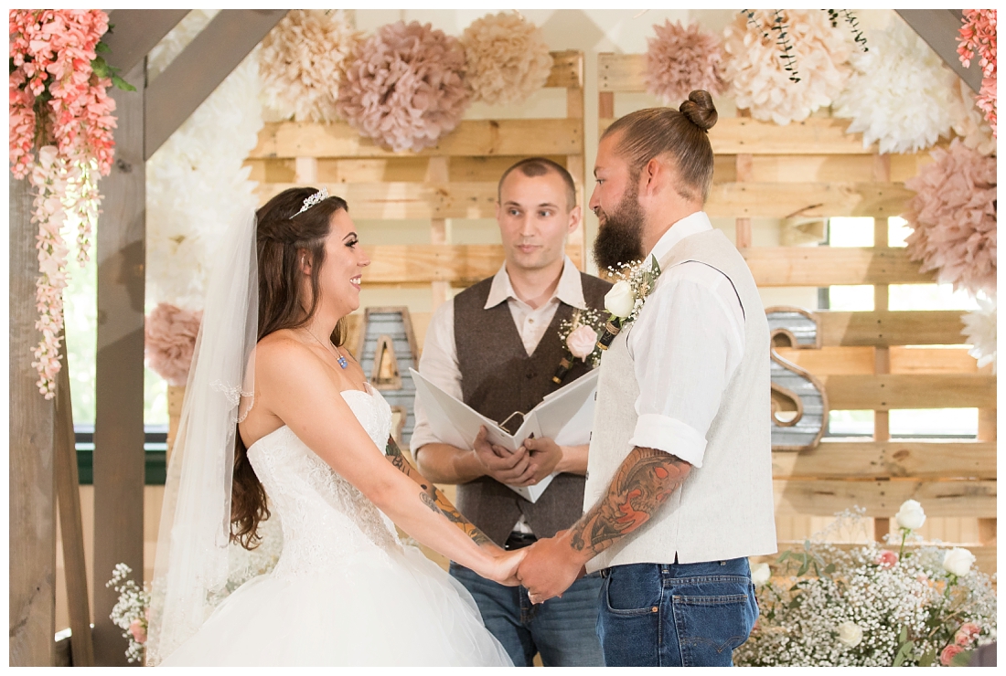 Indoor wedding ceremony. Rustic Wedding Decor. Rose Gold wedding decor. Wooden arbor with flowers. Maryland wedding at Circle D Farm in Woodbine. Maryland Wedding Photographer.