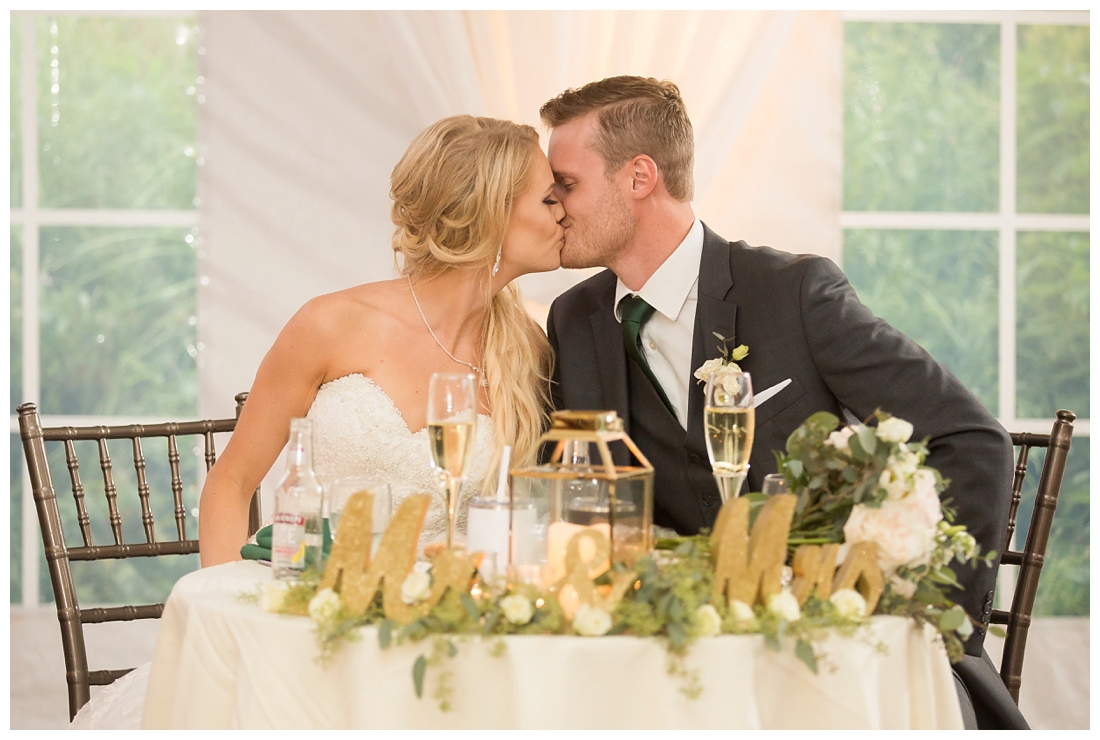 Towson Maryland Catholic Church Ceremony. Joppa Maryland Mountain Branch Golf Club Wedding. The Belvedere bridal wedding preparation.  Bride and Groom Kissing at sweetheart table