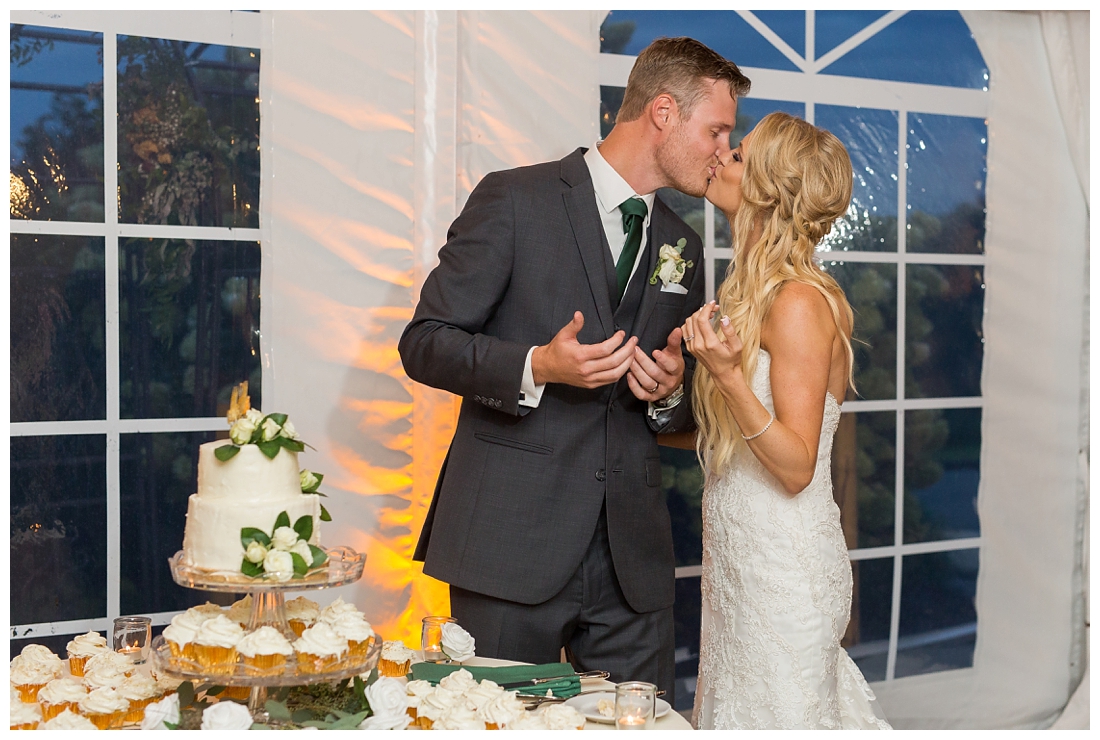 Towson Maryland Catholic Church Ceremony. Joppa Maryland Mountain Branch Golf Club Wedding. The Belvedere bridal wedding preparation.  bride and groom kissing next to the wedding cake after cake smash